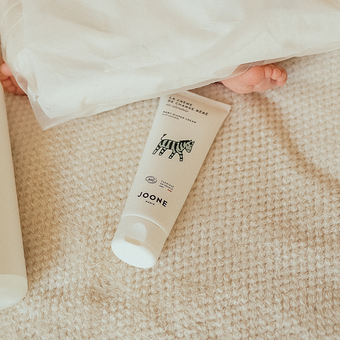 Application d'une crème de change sur la peau du siège d'un bébé lors du change